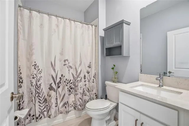 a bathroom with a granite countertop sink a toilet and a mirror