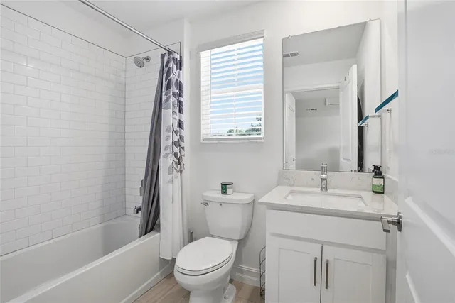 a bathroom with a sink toilet vanity tub and shower
