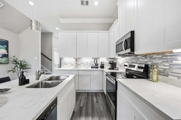 a kitchen with a sink stove top oven and refrigerator