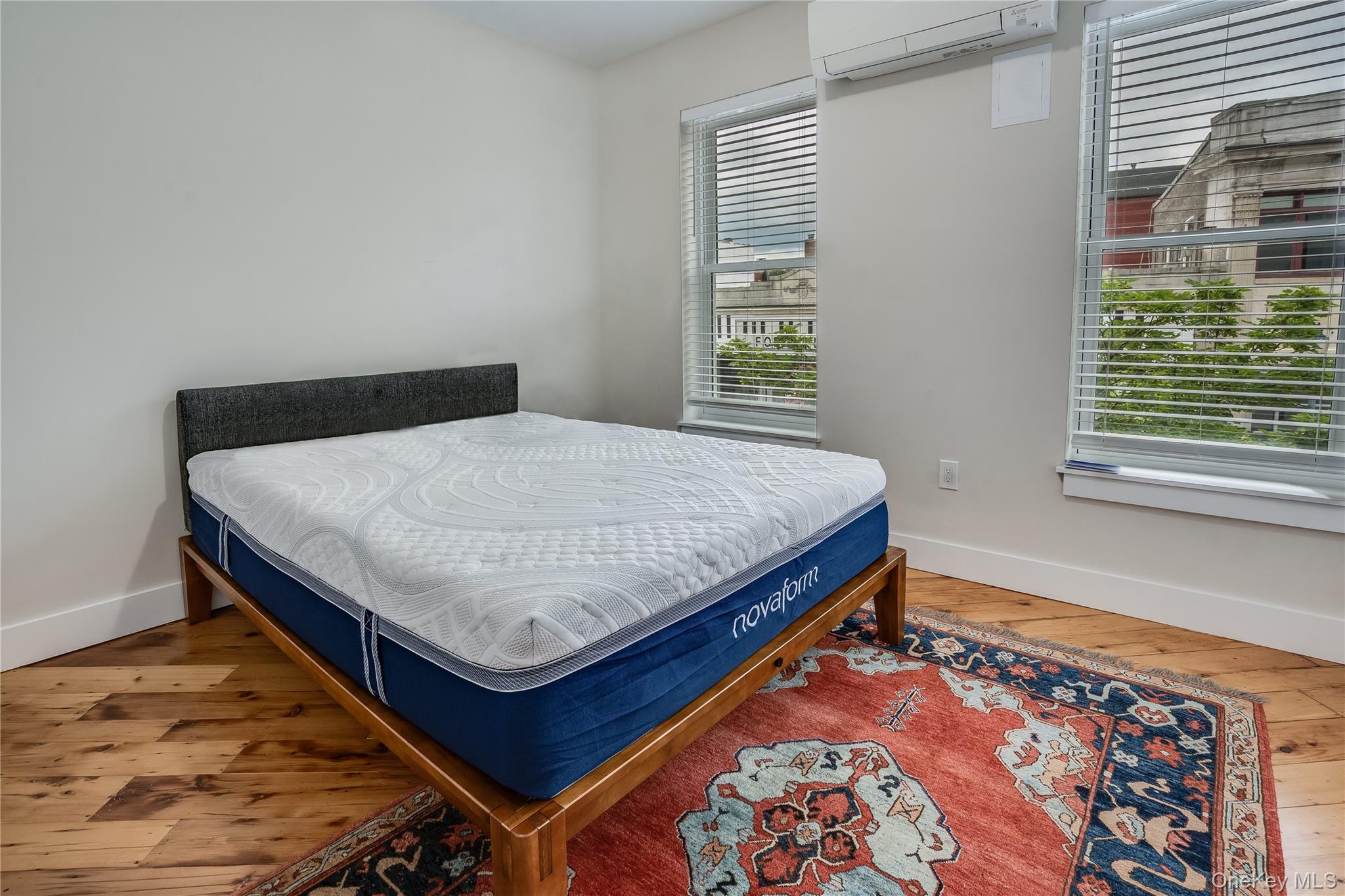 16 South Division Street, Unit 2B Peekskill, NY 10566 - Photo 5 of 8 a bed sitting in a bedroom next to a window