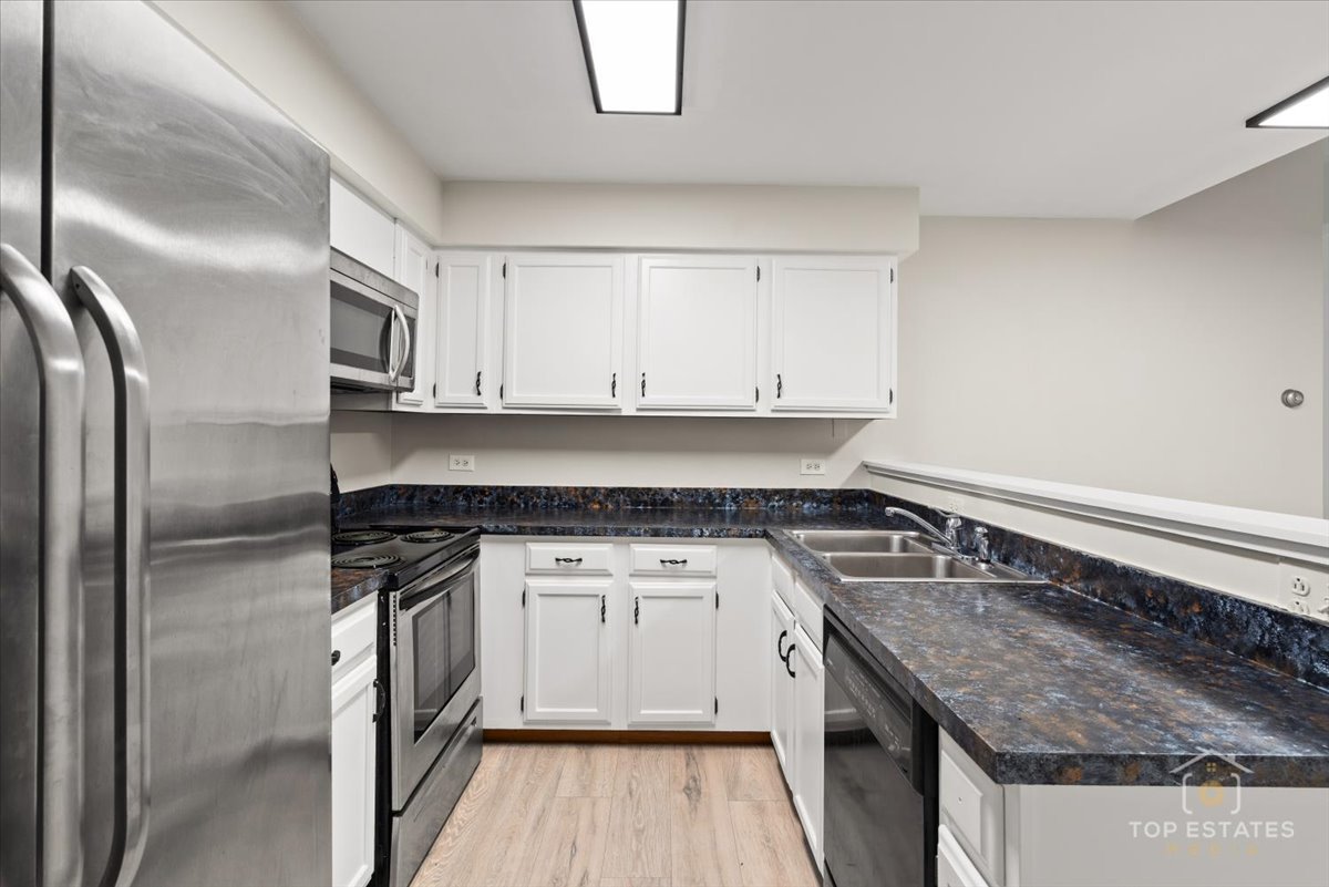 414 Franklin Avenue, Unit 3A River Forest, IL 60305 - Photo 12 of 29 a kitchen with stainless steel appliances granite countertop a stove a sink and a refrigerator