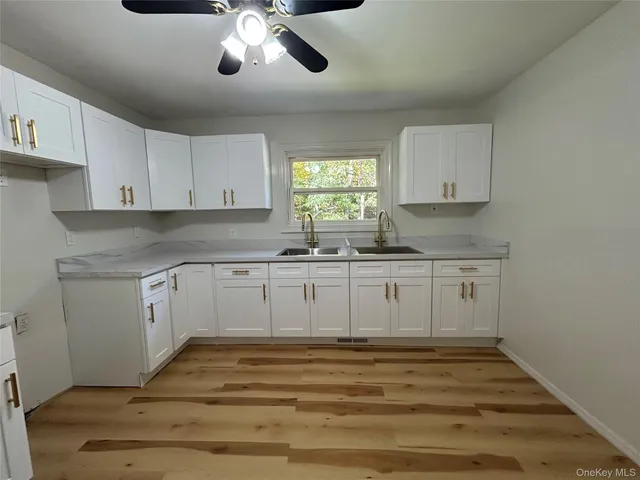 a kitchen with granite countertop white cabinets white stainless steel appliances with a sink and dishwasher