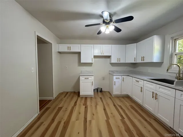 a kitchen with cabinets a sink and wooden floor
