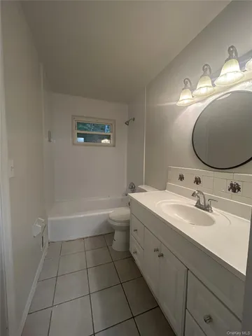 a bathroom with a tub sink toilet and mirror