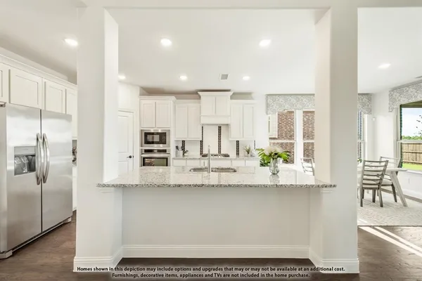 a kitchen with stainless steel appliances kitchen island granite countertop a refrigerator and cabinets