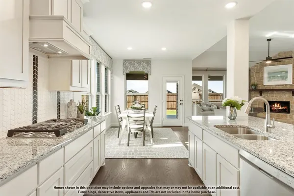 a large kitchen with kitchen island a large counter top space a sink a stove and cabinets