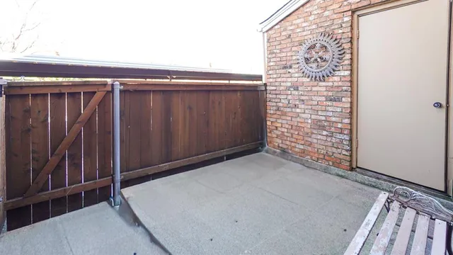 a view of a yard with plants and large trees