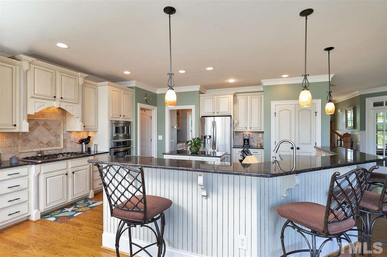 2829 Winter Song Road Raleigh, NC 27614 - Photo 11 of 30 ARTISTIC BACK SPLASH AND SEATS AT THE GRANITE BAR TO WATCH THE COOK/HOST PREPARE A MEAL IN THE OPEN KITCHEN!! CENTER ISLAND OFFERS ADDITIONAL STORAGE, BOOKSHELVES.