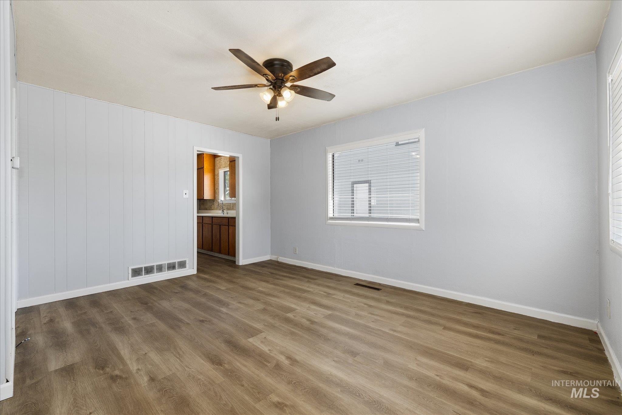 918 West 3rd Street Weiser, ID 83672 - Photo 8 of 36 Spacious room featuring wood-finish flooring, light blue walls, and a ceiling fan with integrated lighting