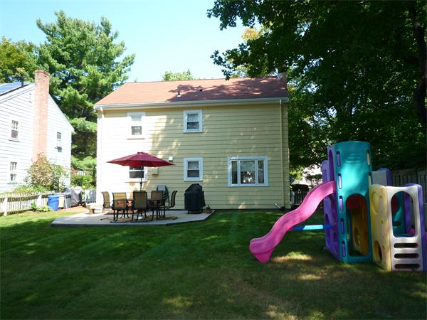 9 Bridge Street Lexington, MA 02421 - Photo 18 of 20 a view of backyard of house with outdoor seating and slide