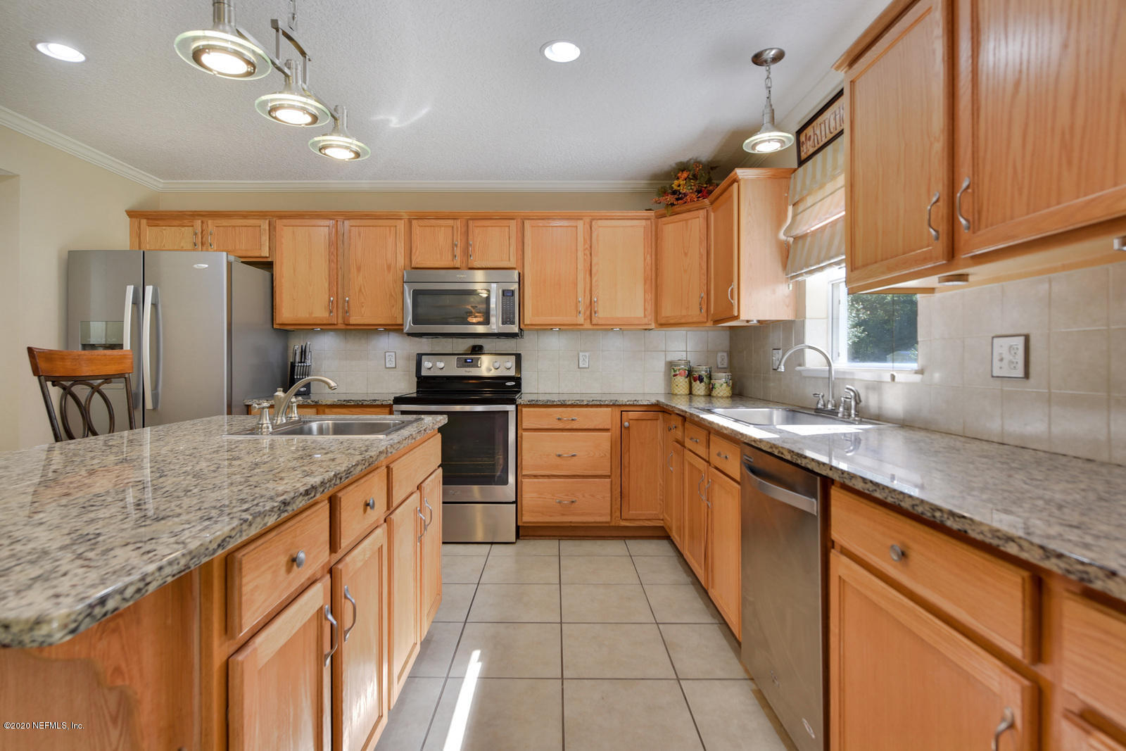 55371 Bear Run Road Callahan, FL 32011 - Photo 8 of 29 a kitchen with stainless steel appliances granite countertop a sink counter space cabinets and a large window