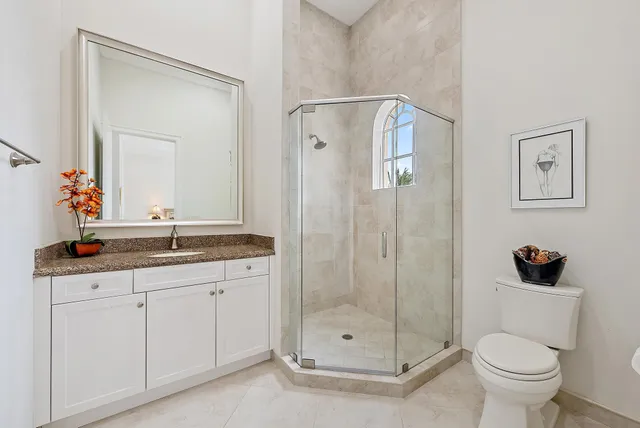 a bathroom with a granite countertop sink mirror and toilet