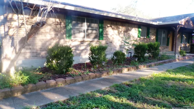 a backyard of a house with plants and outdoor seating