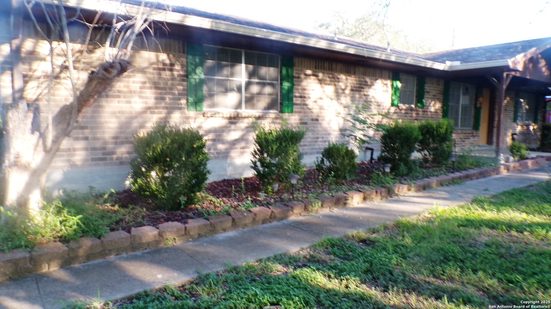 a backyard of a house with plants and outdoor seating