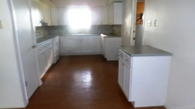 a kitchen with a sink a refrigerator and cabinets