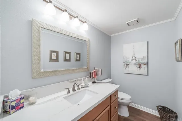 a bathroom with a granite countertop sink mirror vanity and toilet