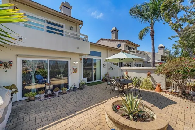 a view of a patio with table and chairs potted plants and a large tree