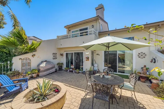 a backyard of a house with table and chairs