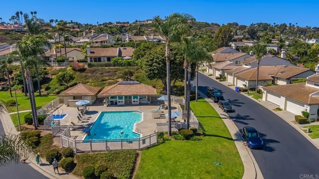 an aerial view of residential houses with outdoor space and swimming pool