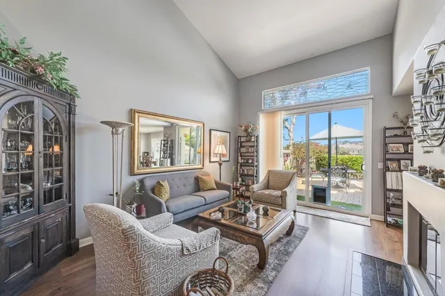a living room with furniture large window and wooden floor
