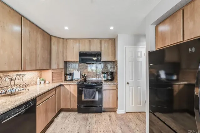 a kitchen with kitchen island granite countertop a sink stove and refrigerator