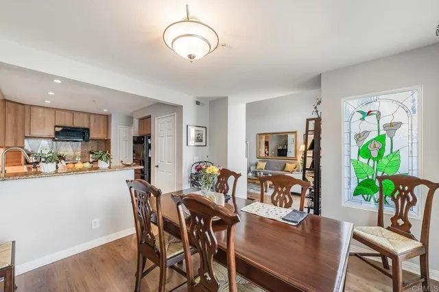 a dining room with furniture potted plants and wooden floor