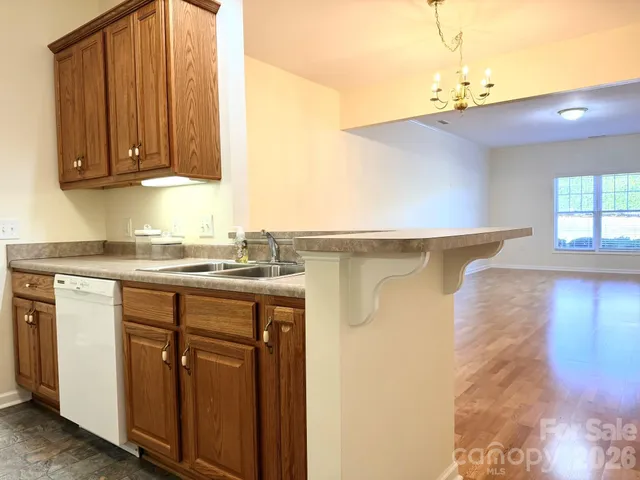 a kitchen with stainless steel appliances granite countertop a refrigerator oven a stove with wooden cabinets