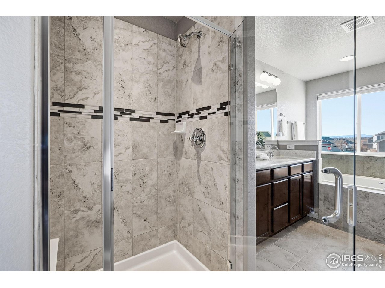 551 Capitol Reef Court Berthoud, CO 80513 - Photo 18 of 42 Large walk-in shower with a bench and soaking tub