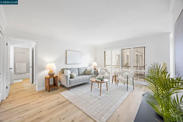 a living room with furniture hard wood floor and a table