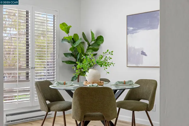 a dining room with furniture and a potted plant