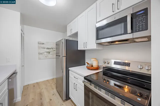 a kitchen with stainless steel appliances a refrigerator and a microwave