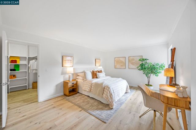 a bedroom with a bed table and a flat screen tv