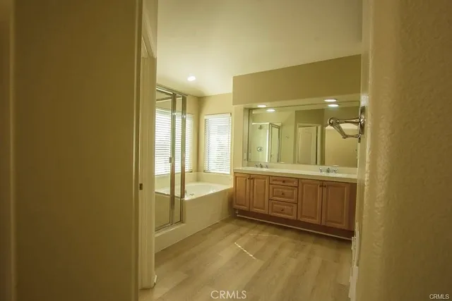 a bathroom with a tub sink shower and mirror