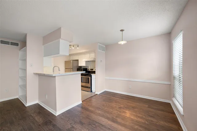 a kitchen with a refrigerator and a stove top oven