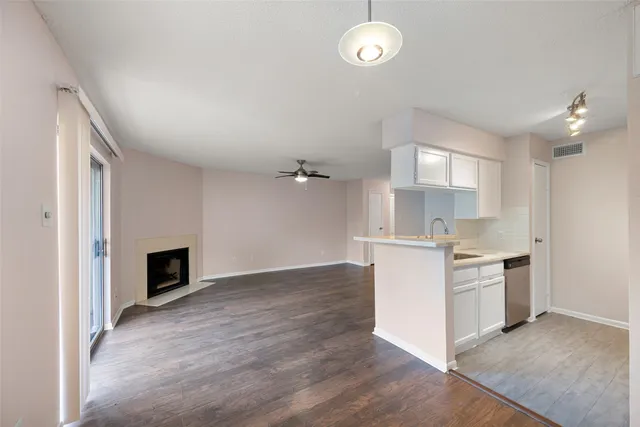 an empty room with kitchen and fireplace
