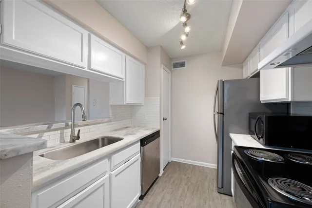 a kitchen with a sink appliances and cabinets