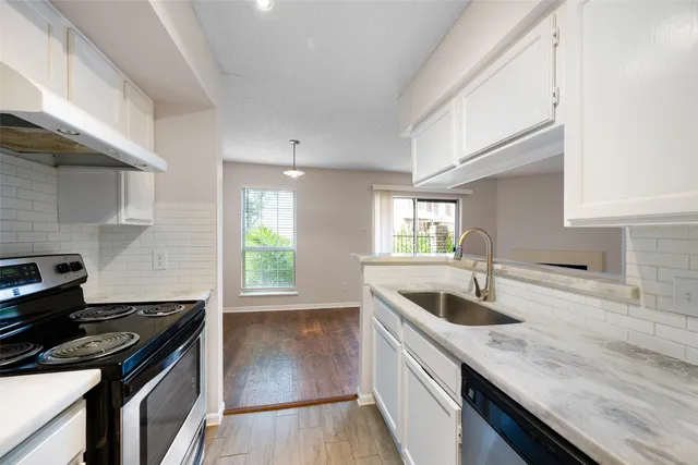 a kitchen with a sink stove top oven and cabinets