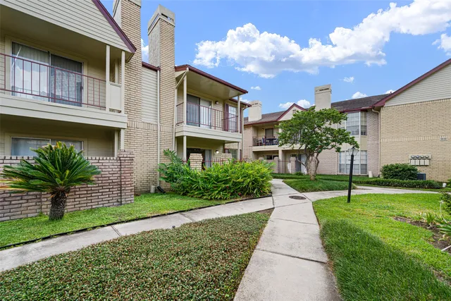 a front view of a house with a yard and potted plants
