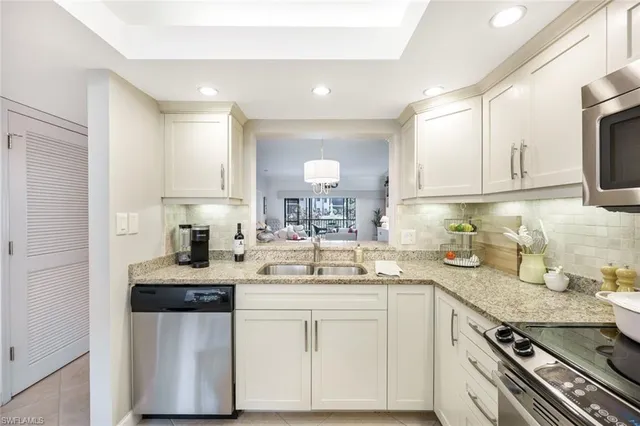 a kitchen with sink a stove and cabinets