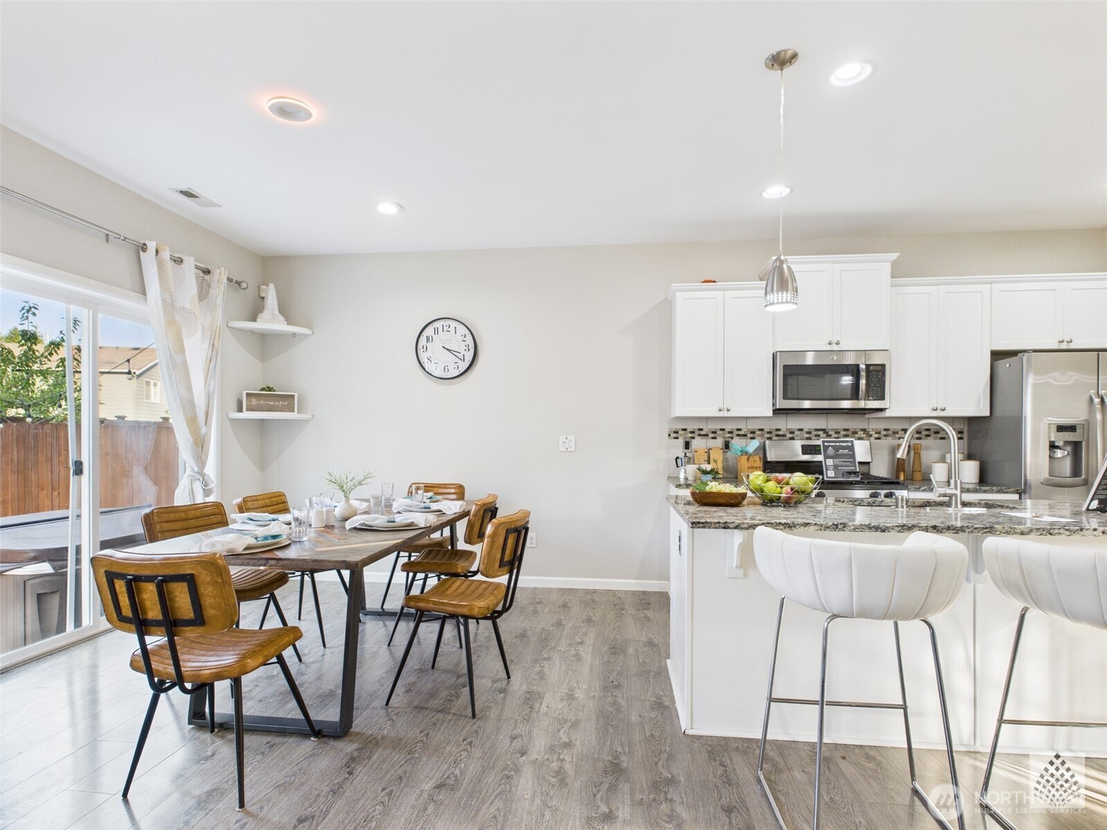 3625 202nd Pl S East Bothell, WA 98012 - Photo 7 of 31 a kitchen with stainless steel appliances kitchen island granite countertop a dining table chairs and a refrigerator