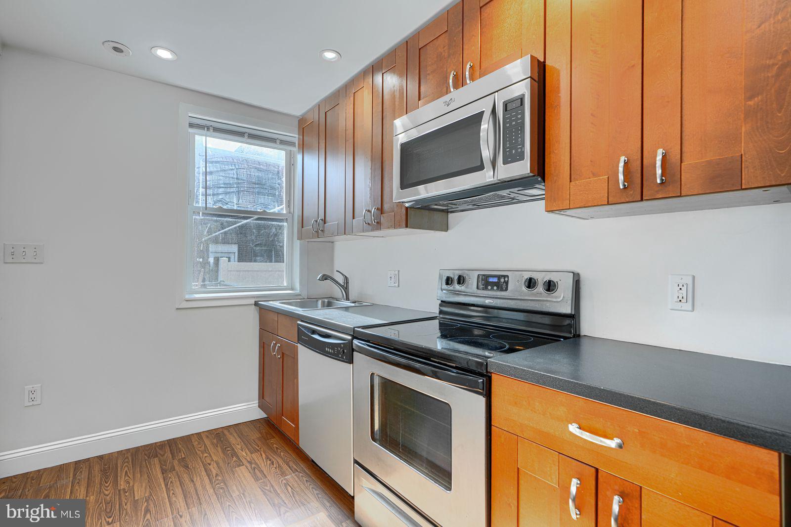 1026 Patapsco Street Baltimore, MD 21230 - Photo 5 of 24 a kitchen with stainless steel appliances granite countertop a stove a microwave and a sink
