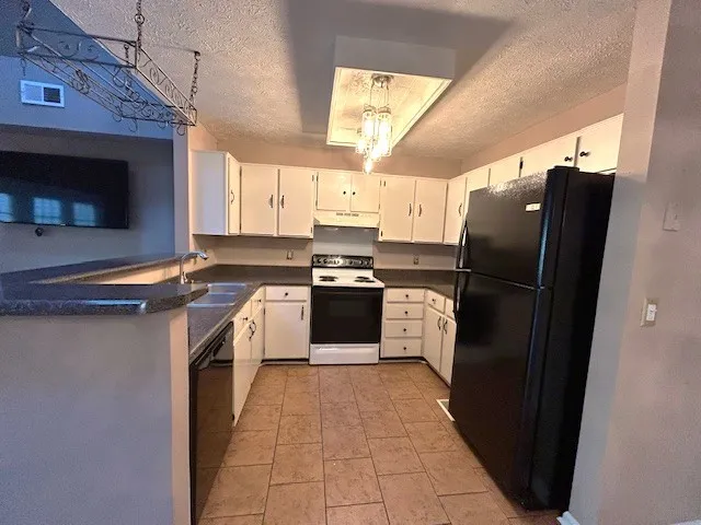 a kitchen with granite countertop a refrigerator and a stove
