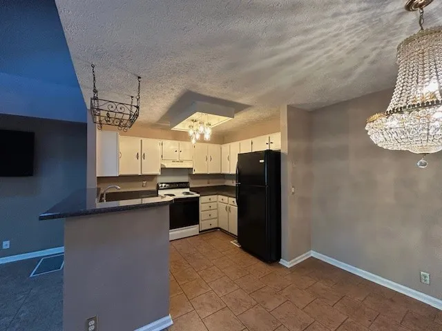 a kitchen with granite countertop a refrigerator stove and sink
