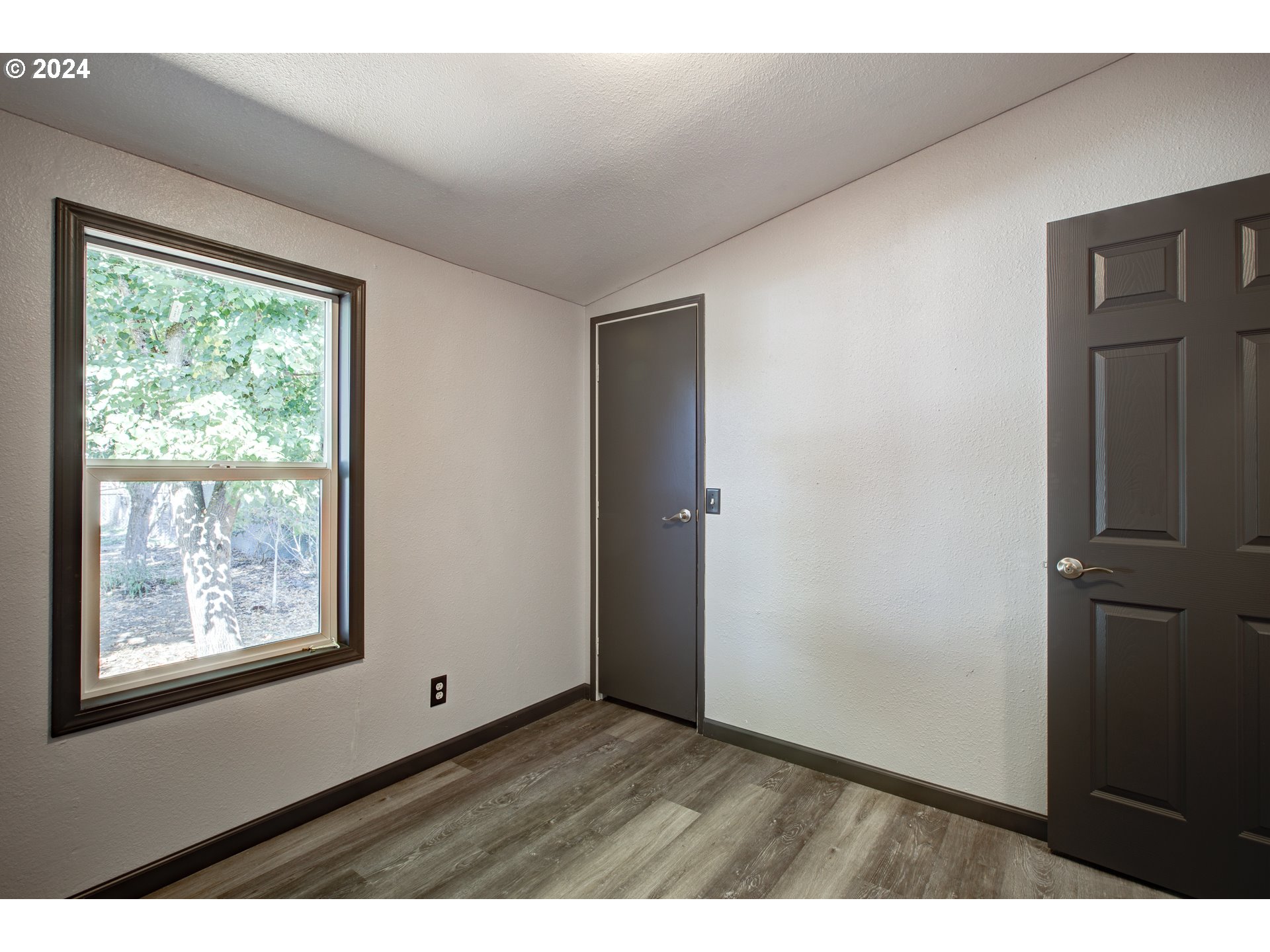 2438 Austin Road Roseburg, OR 97471 - Photo 38 of 48 an empty room with wooden floor and windows