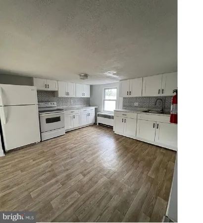 a kitchen with granite countertop a stove top oven and cabinets