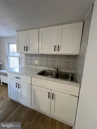 a kitchen with a sink a stove and cabinets