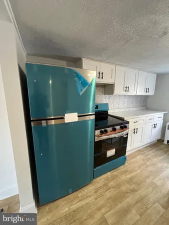 a kitchen with granite countertop a refrigerator and a stove