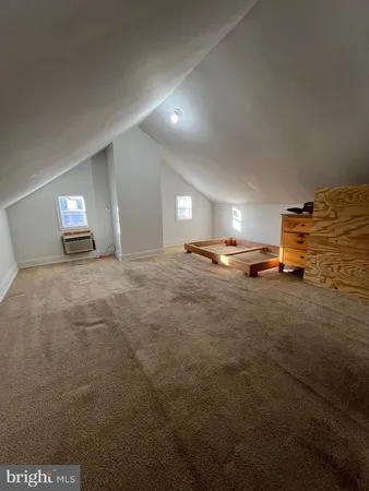 a spacious bedroom with a bed and wooden floor