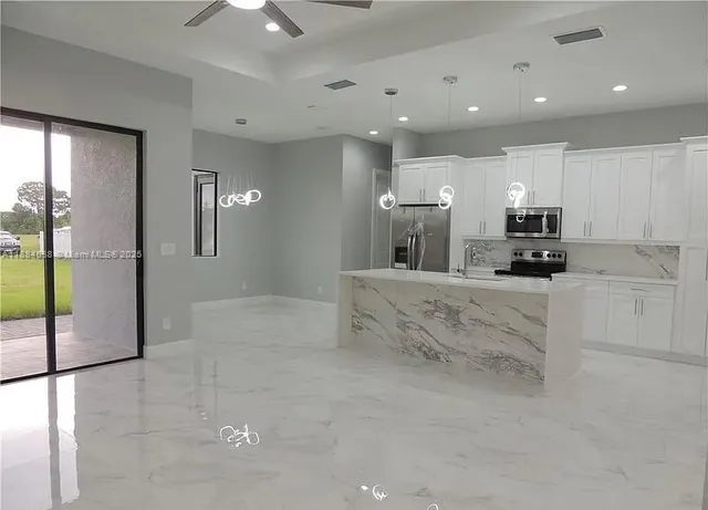 a view of kitchen with refrigerator and window