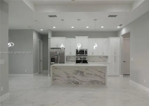 a large bathroom with a large mirror vanity and refrigerator